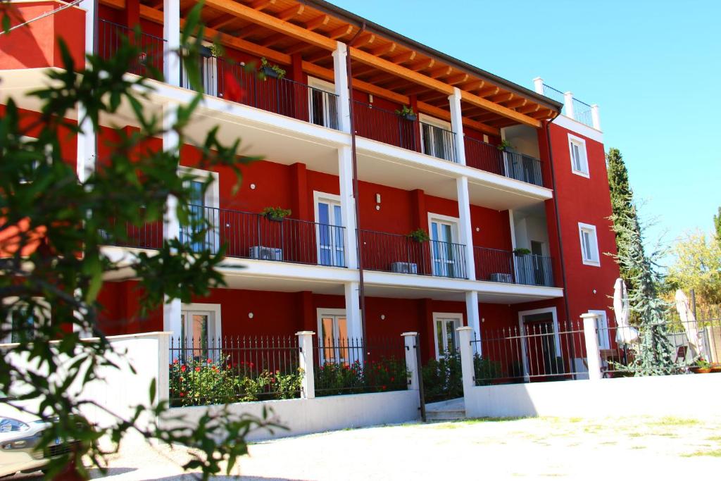 un edificio rojo con columnas blancas y balcones rojos en Residence Candeloro, en Francavilla al Mare