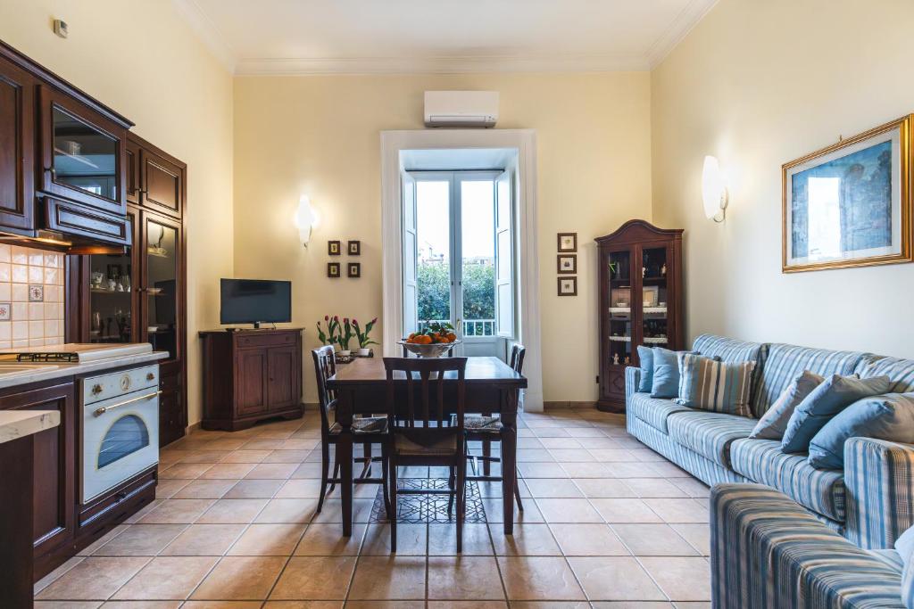 a kitchen and living room with a table and a couch at Flat Rosanna in Sorrento