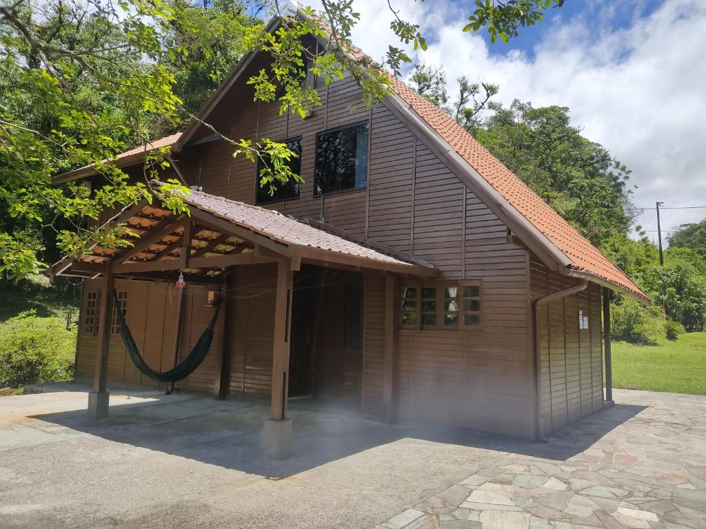 uma casa com uma rede em frente em Casa de campo em São José dos Pinhais