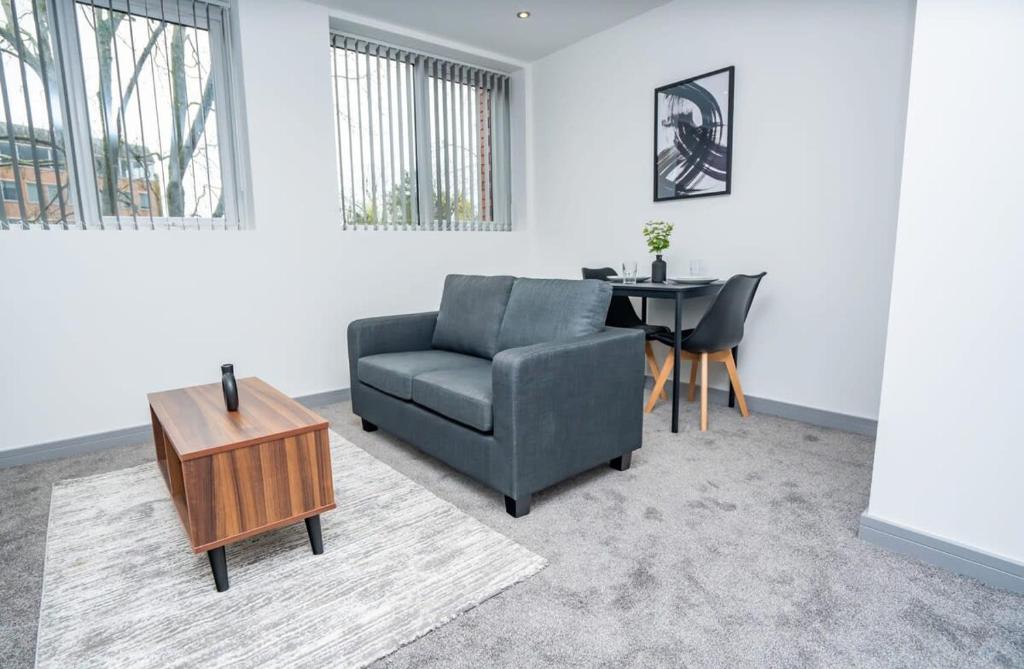 a living room with a chair and a table at Bright and Modern 1 Bed Apartment in Redditch in Redditch