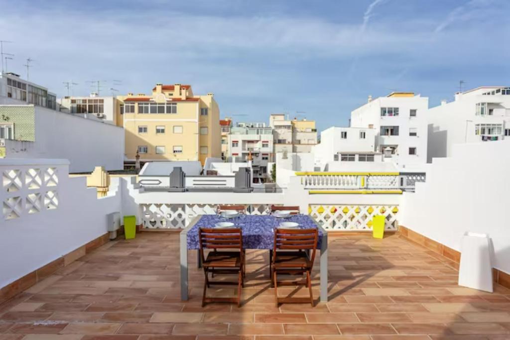 a table and chairs on a balcony with buildings at BLife Galya private rooms in Faro