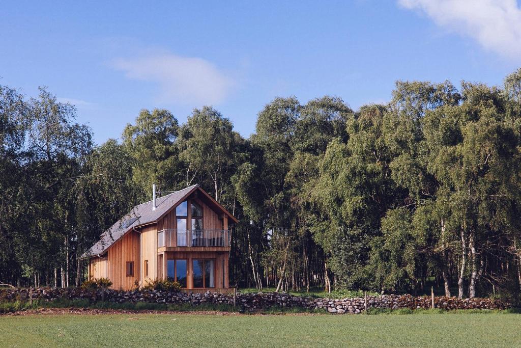 a house in the middle of a field with trees at Lodges at the Mains in Inverness
