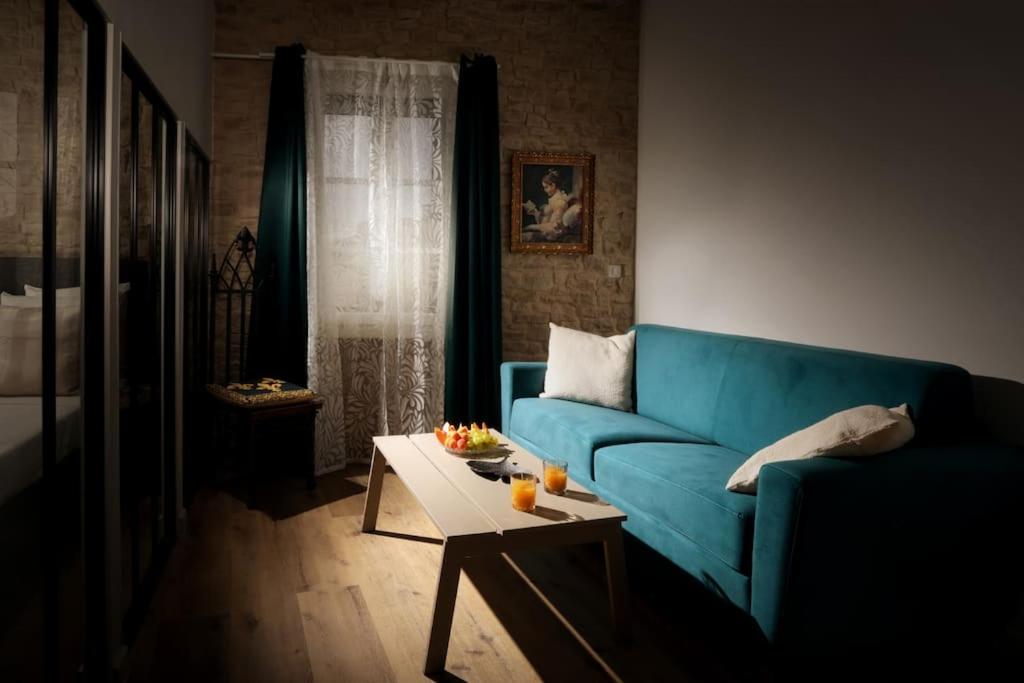 un salon avec un canapé bleu et une table basse dans l'établissement La Demeure du Chevalier d'Argent- parking gratuit, à Carcassonne