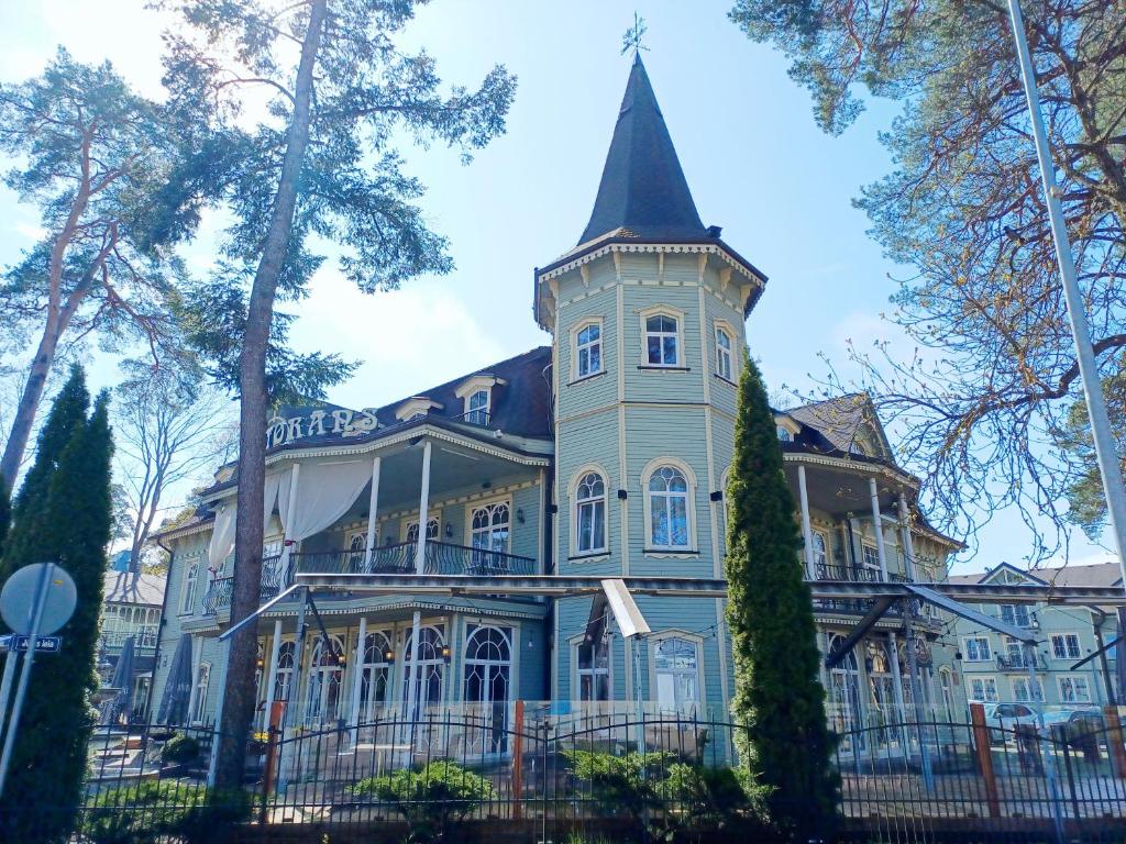 a large house with a tower on top of it at Pegasa Pils Spa Hotel in Jūrmala