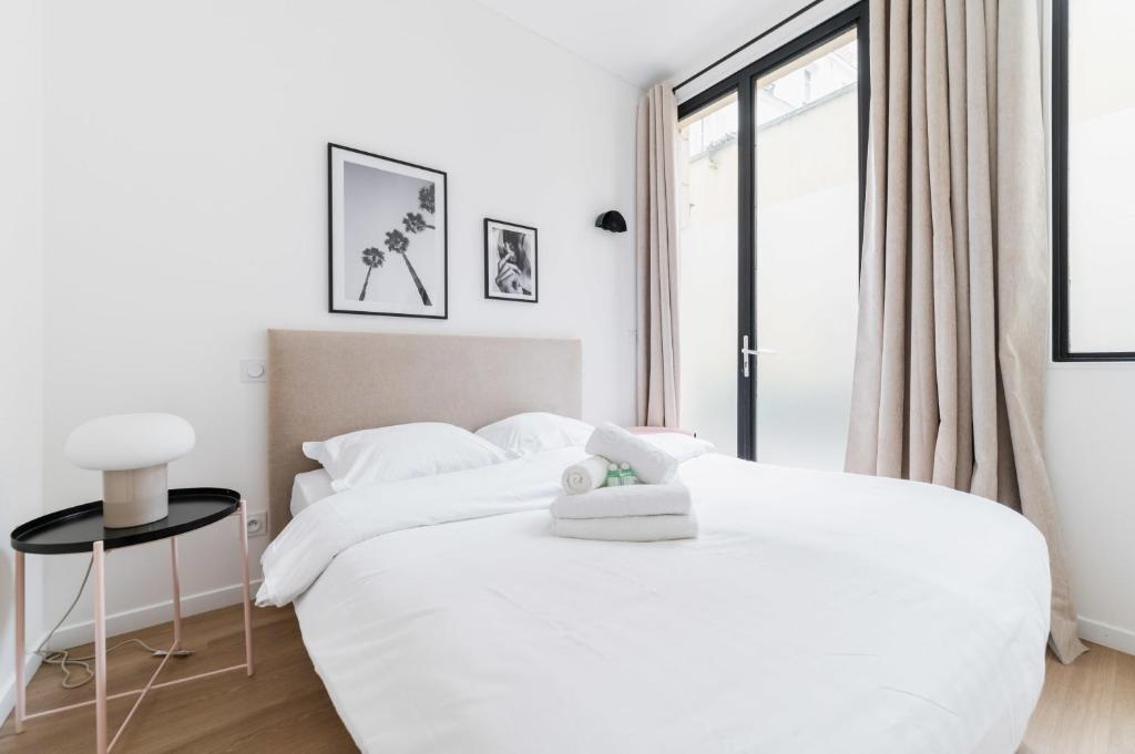 - 2 lits blancs dans une chambre blanche avec fenêtre dans l'établissement Appartement luxueux avec salle de bains de reve 6P - FLAT-GUEST, à Paris