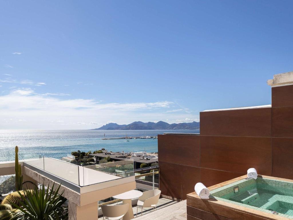 a building with a swimming pool and the ocean at Mondrian Cannes in Cannes
