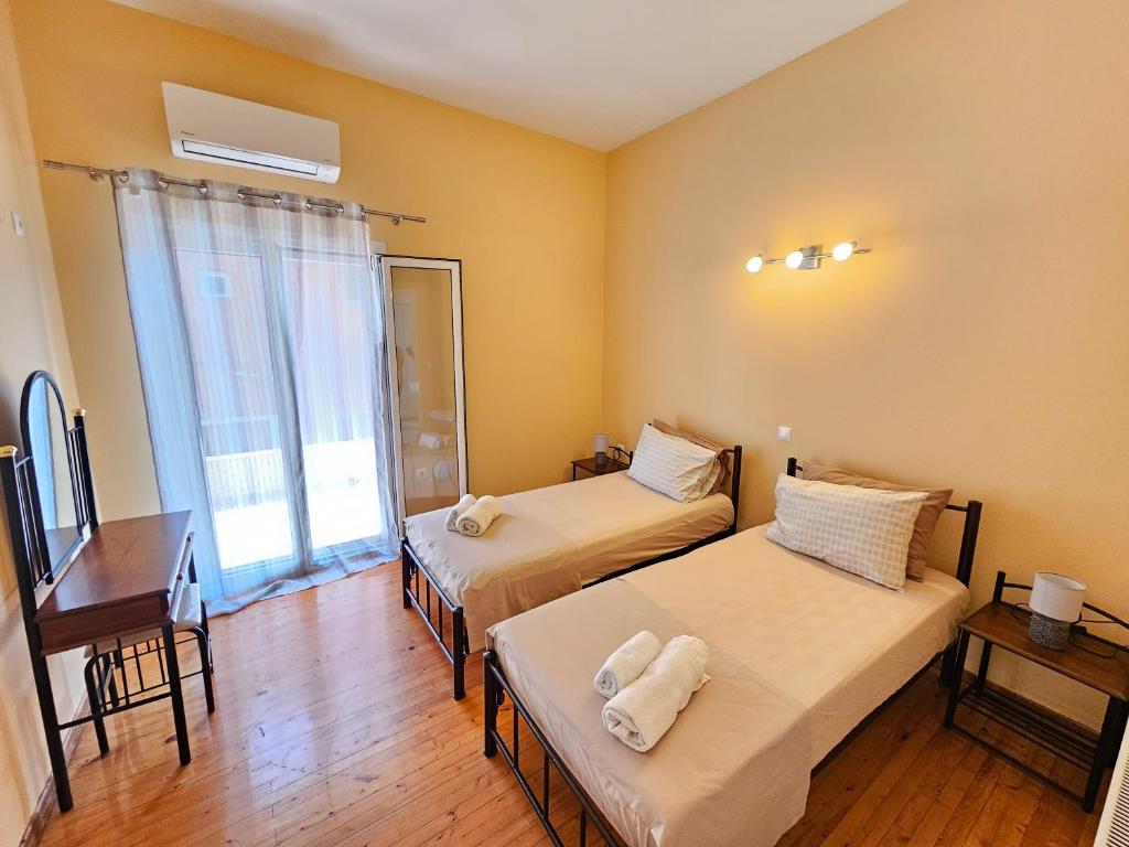 イプソスにあるStamatis Family Apartmentのベッド2台と机と窓のある部屋