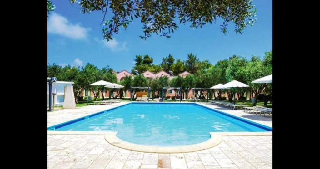 una grande piscina con ombrelloni in un resort di Family Village Otranto ad Alimini