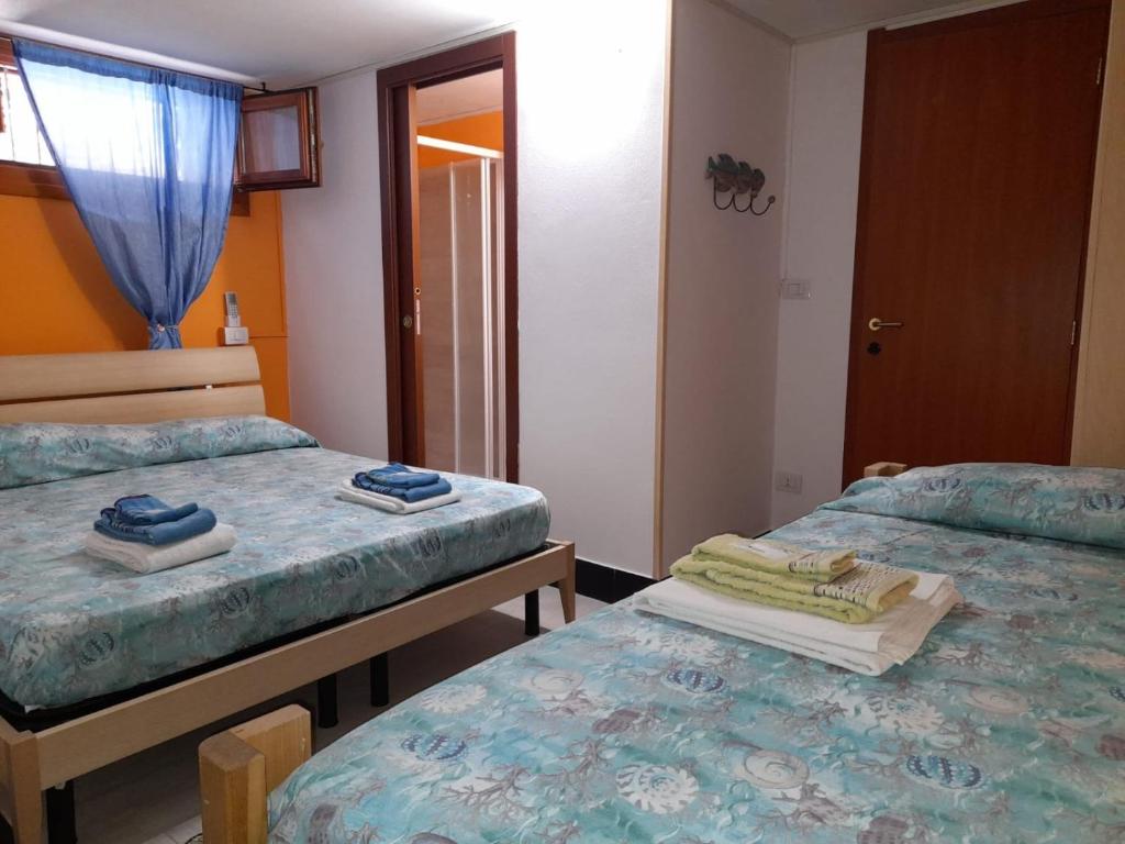 a room with two twin beds and a window at BBrezza Marina in Stintino