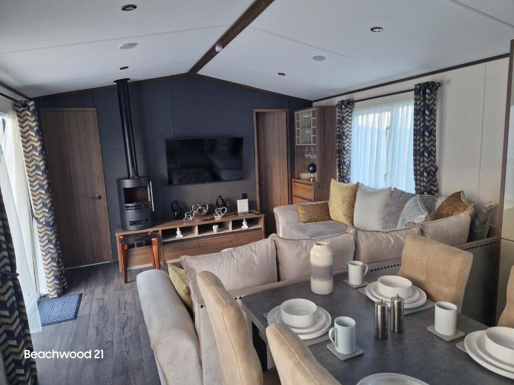 a living room with a couch and a table at Beachwood 21 in Camber