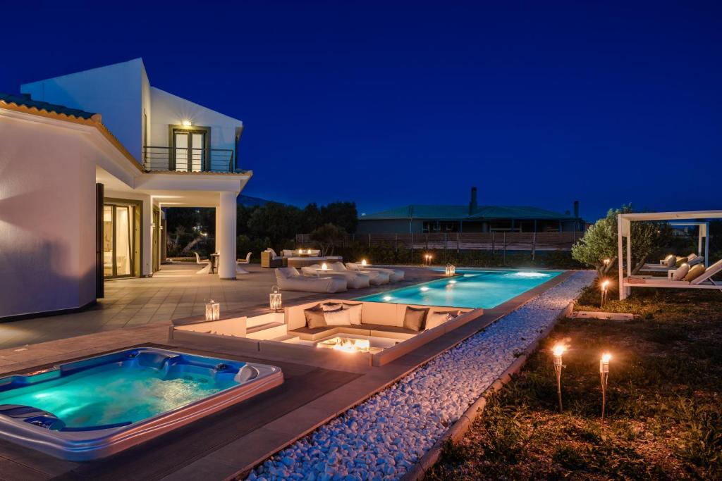 un patio trasero con piscina por la noche en Villa Felicity en Svoronata