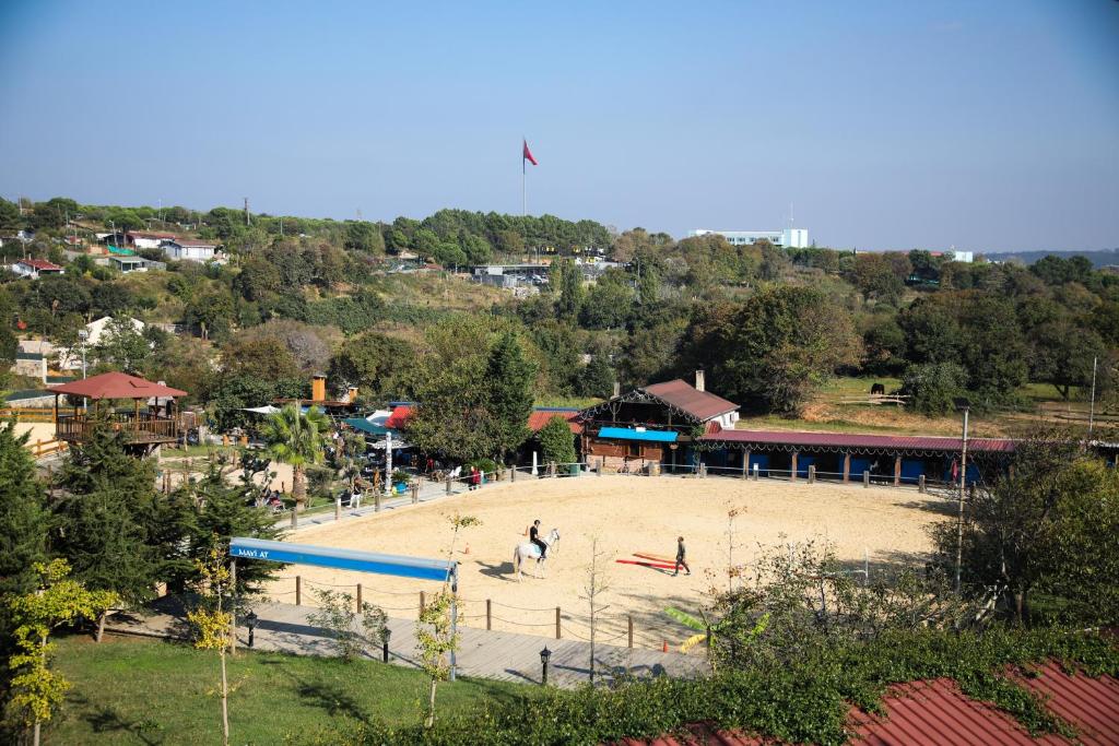 a playground in a park with people playing in the sand at MAVİ AT HOTEL Blue Horse in Gümüşdere