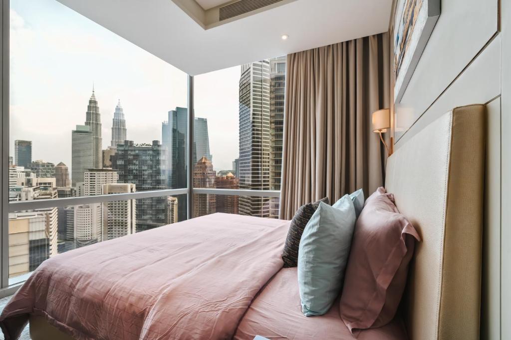 a bedroom with a bed and a large window at Luxury 2BR Designer Suite above Pavilion Mall in Kuala Lumpur