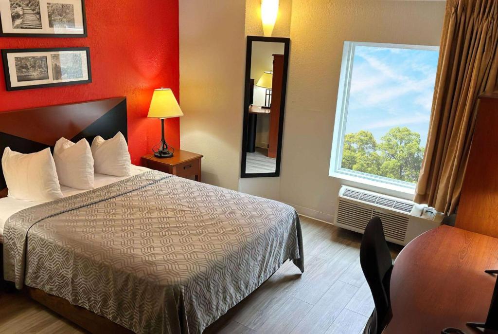 a hotel room with a bed and a window at Howard Johnson by Wyndham Urbana in Champaign