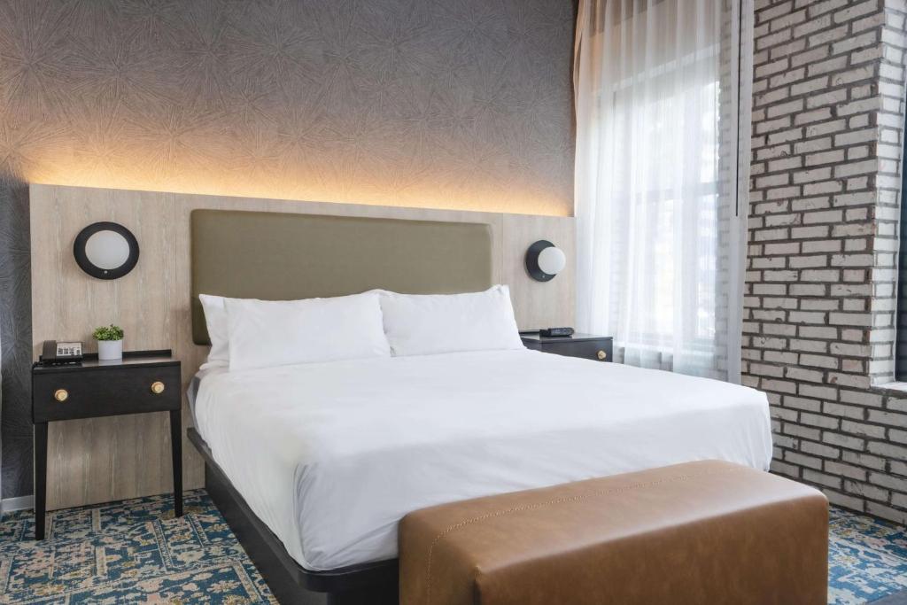 a bedroom with a large white bed and a window at Origin Atlanta, a Wyndham Hotel in Atlanta