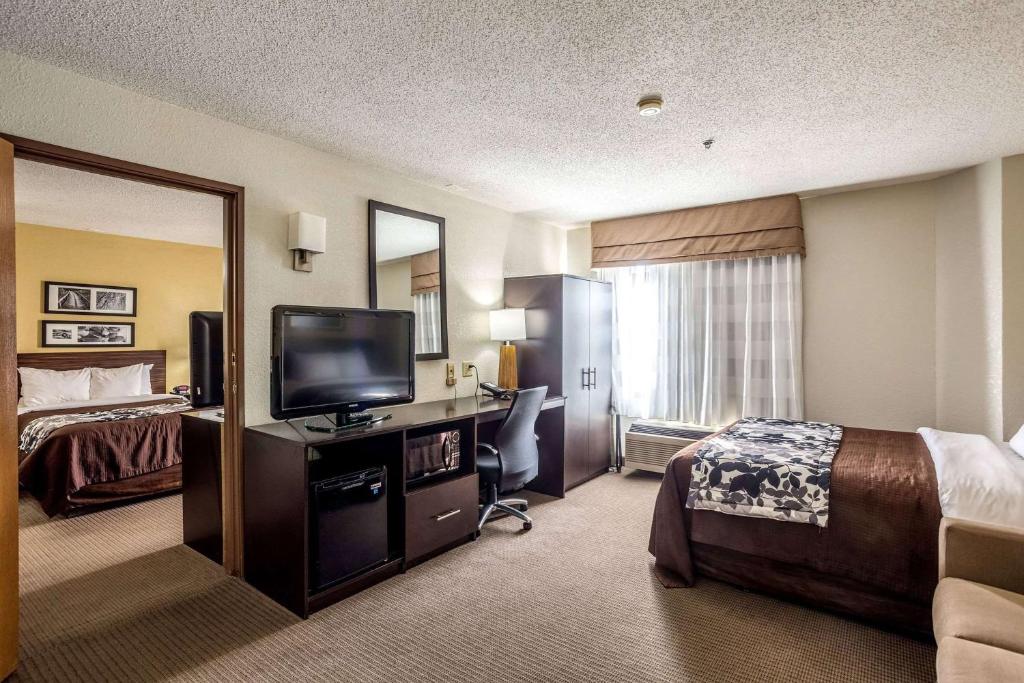 a hotel room with a bed and a flat screen tv at Wingate by Wyndham Owensboro in Owensboro