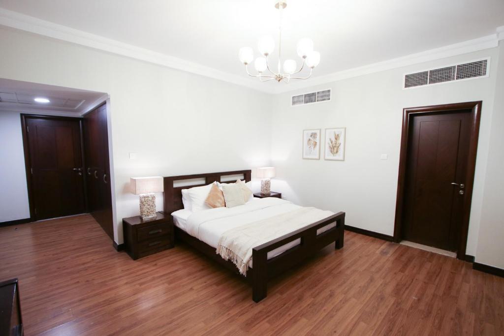 a bedroom with a bed and a chandelier at Aman Plaza in Juffair