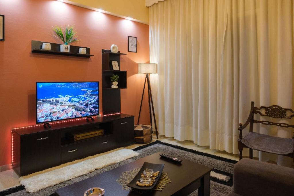 a living room with a flat screen tv on a wall at sophia's apartment in Volos