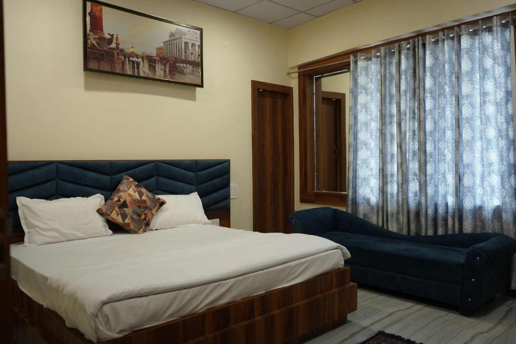 una camera con letto e sedia blu di Maharaja Hotel and Restaurant a Ratia