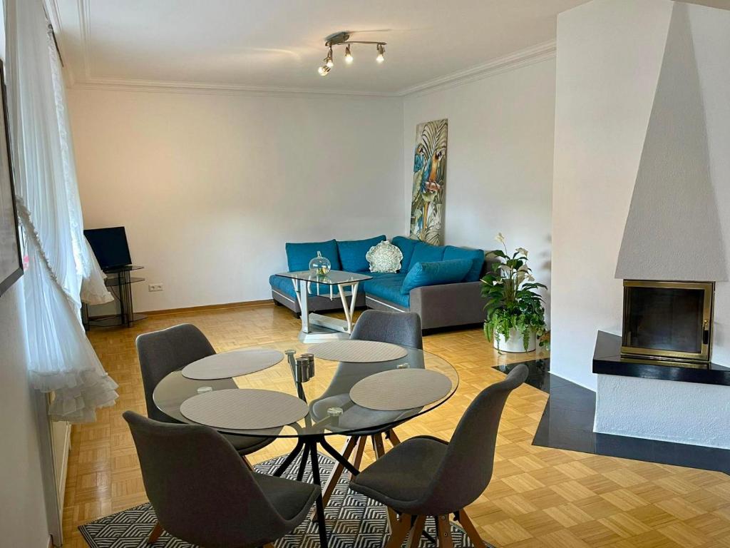 sala de estar con sofá azul, mesas y sillas en KobyHome Apartment en Enger