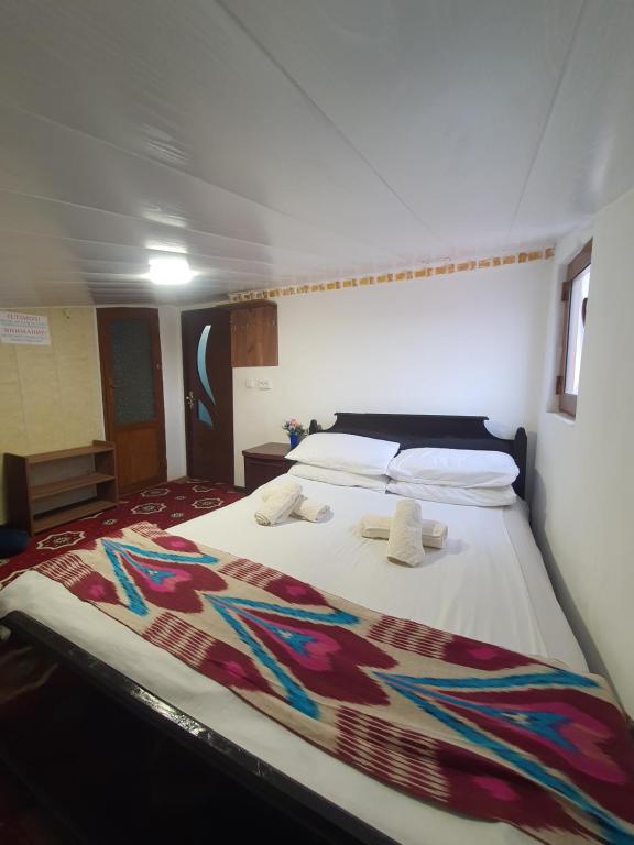 ein Schlafzimmer mit einem großen Bett mit einer bunten Decke darauf in der Unterkunft UMAR HOSTEL in Samarkand