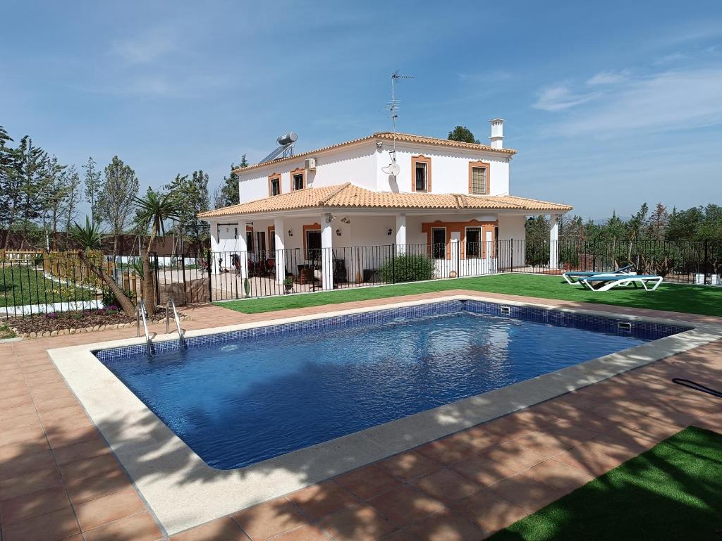 a house with a swimming pool in front of a house at casa sierrecilla in Fuente de Piedra