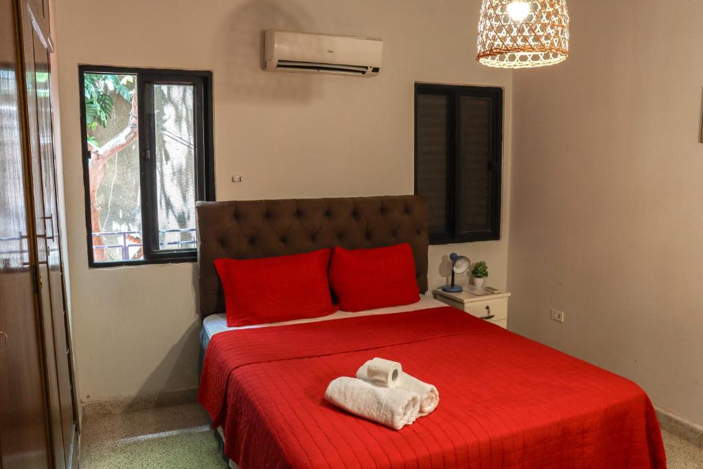 a bedroom with a red bed with a towel on it at Renty Paraguay in Asuncion