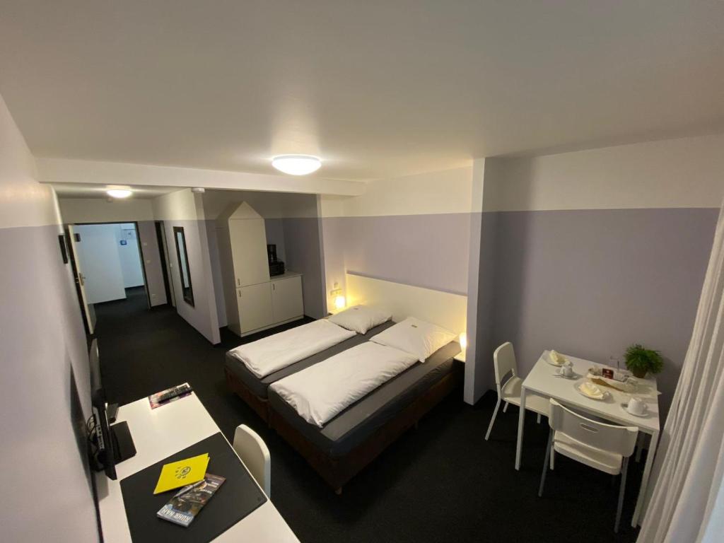 una camera d'albergo con letto e tavolo di Hotel U - Aktienstraße 241 in Mülheim an der Ruhr a Mülheim an der Ruhr