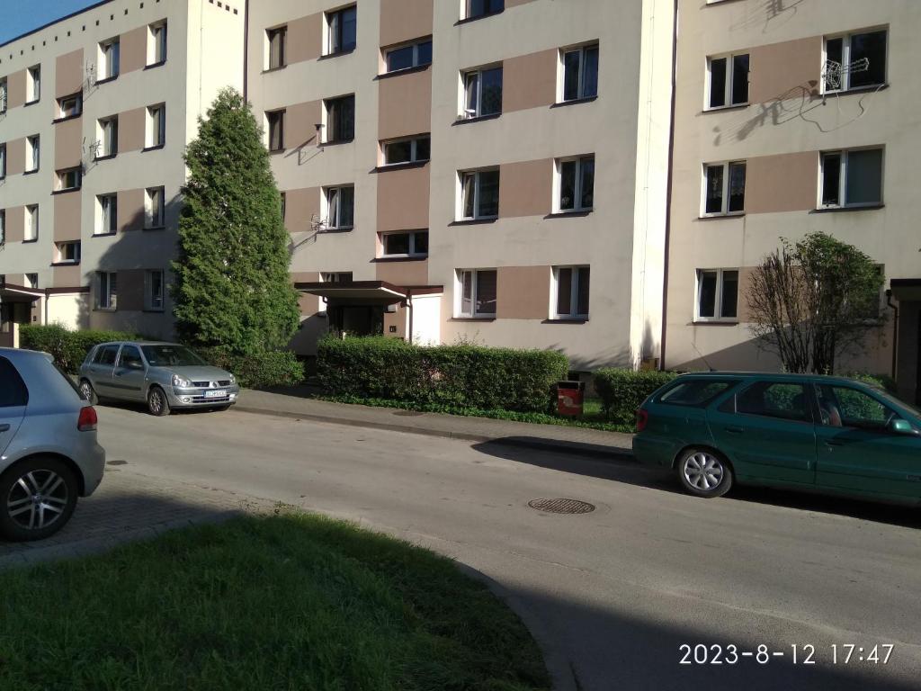 two cars parked in a parking lot in front of a building at FEIDUM quarters rooms in Trzebinia