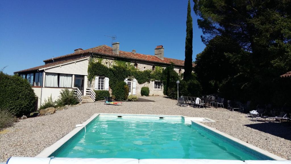una casa con piscina frente a ella en Quatre Vents, en Lagarrigue