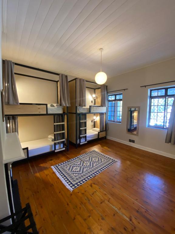 an empty room with bunk beds and a wooden floor at Villa Viva Cape Town in Cape Town