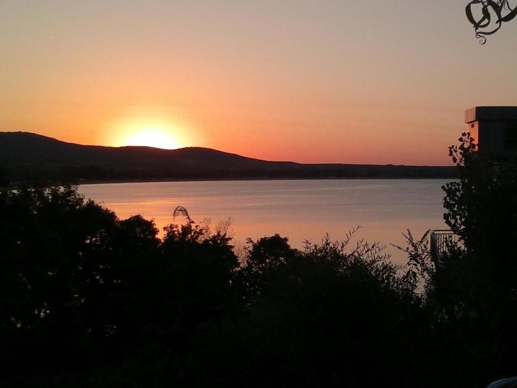 een zonsondergang boven een waterlichaam met zonsondergang bij Ganze Wohnung in Tsentar mit Schönem Garten und Neben dem Strand in Sozopol