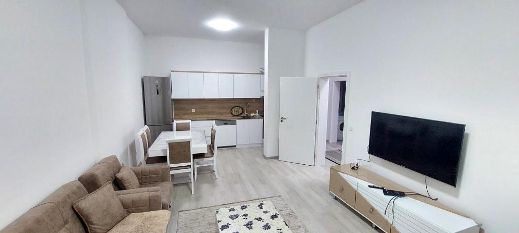 un soggiorno con divano, tavolo e TV di 1st Story Apartment for rent 2 bedrooms', 1 balcony, 1 saloon & kitchen a Ferizaj