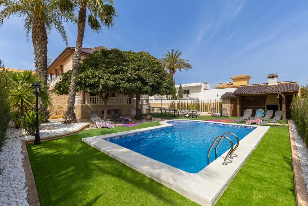 una piscina en un patio con palmeras en Seaside Elegance by Fidalsa, en La Manga del Mar Menor