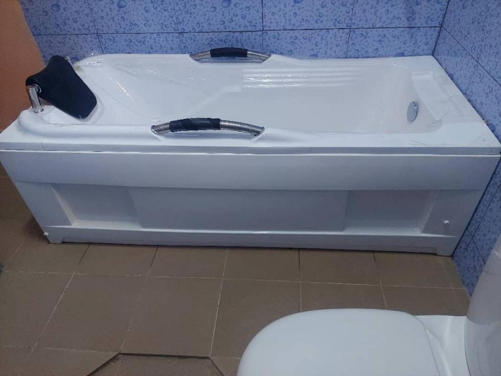 a white bath tub in a bathroom with a toilet at Cool meuble 2 in Ouagadougou