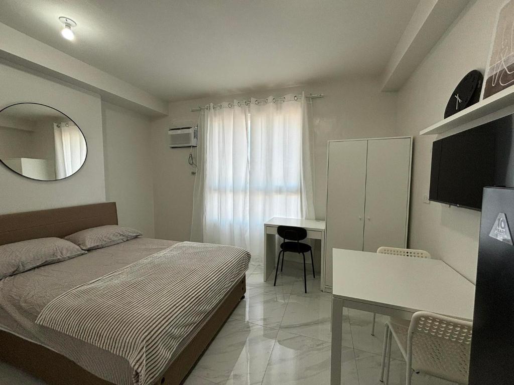 a bedroom with a bed and a desk and a mirror at Casa Mira Guadalupe by Leera's Condo in Cebu City