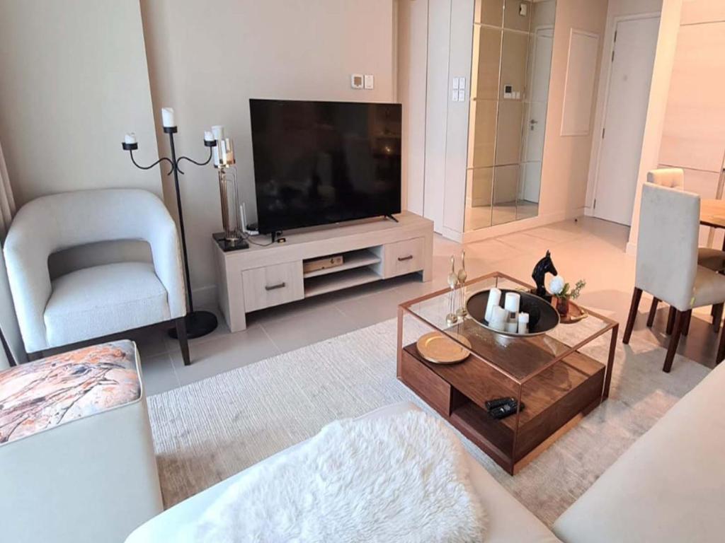 a living room with a flat screen tv and a table at Marassi shores - 310 in Durrat Al Bahrain