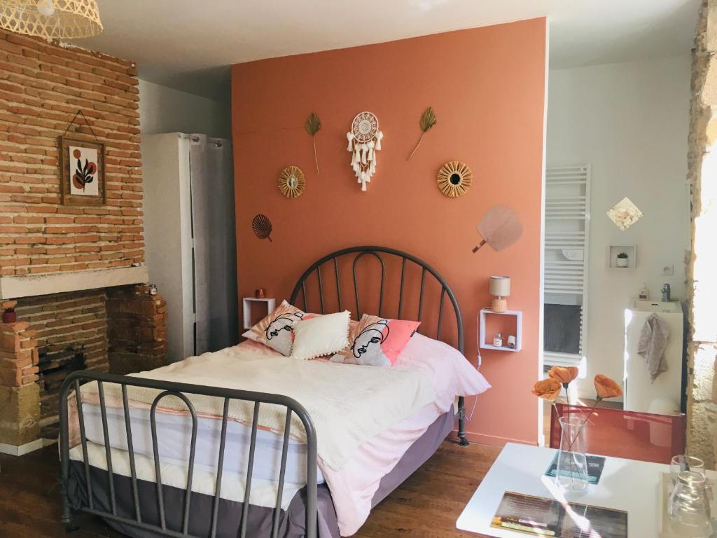 une chambre avec un lit et un mur de briques dans l'établissement Les chambres d'Ursule, à Tartas