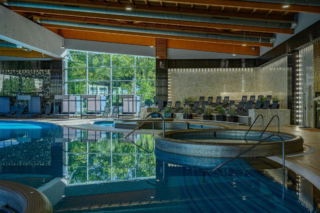 una gran piscina con bañera de hidromasaje en un edificio en Hotel Azur Siofok, en Siófok