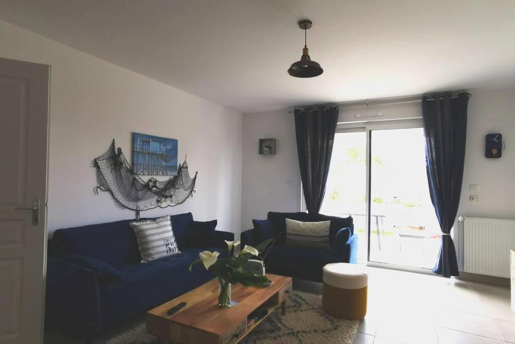 un salon avec un canapé bleu et une table dans l'établissement ! NEW ! Maison neuve classée 3* Saint palais, à Saint-Palais-sur-Mer
