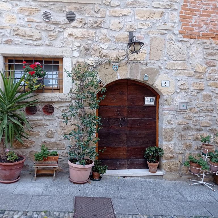 a stone building with a wooden door and potted plants at Casa Vacanza Gaia in Costa di Mezzate