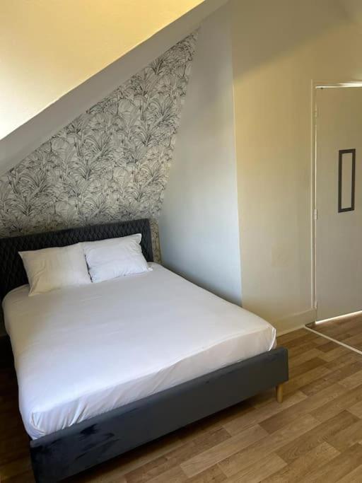 - un lit blanc dans une chambre avec un mur dans l'établissement Duplex Huper, à Amiens