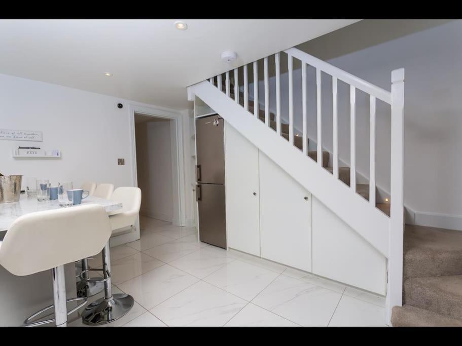 a white kitchen with a staircase and a white chair at Churchview in Cahersiveen