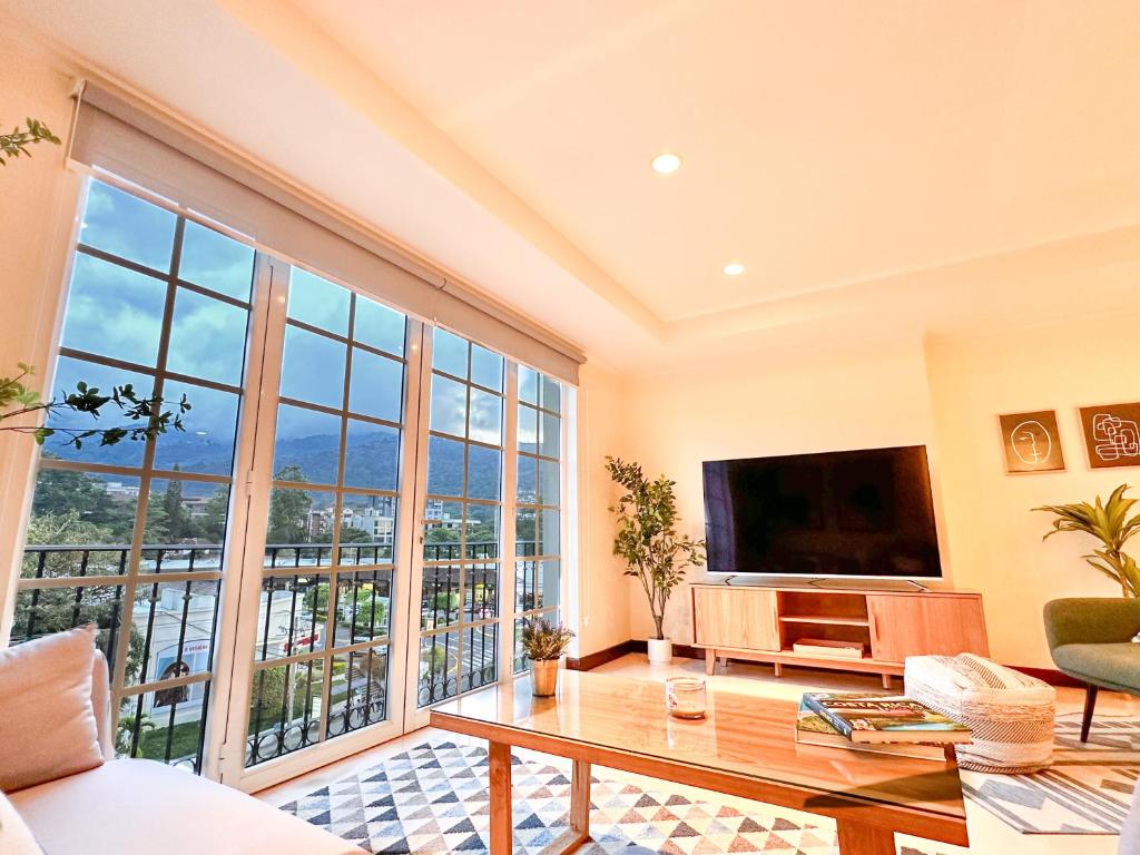 sala de estar con TV y ventana grande en Prime Location Escazu Mountain View & Excellent for medical recovery en San Rafael