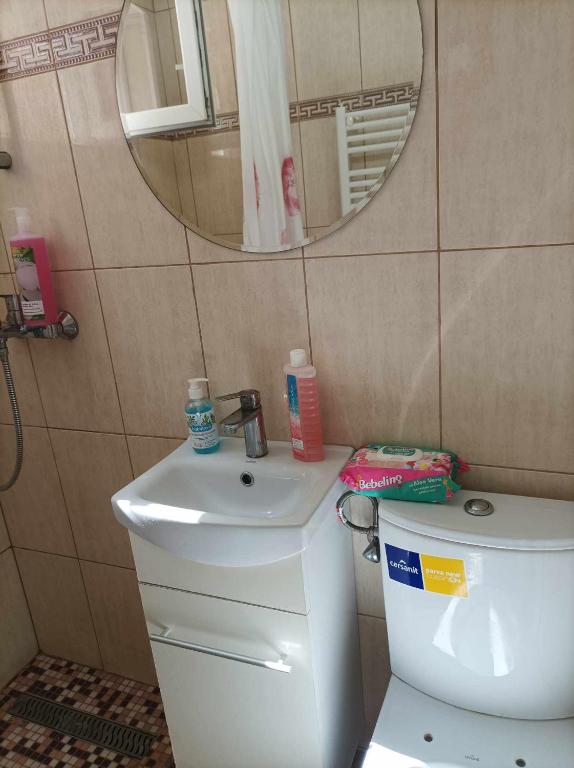 ein Badezimmer mit einem WC, einem Waschbecken und einem Spiegel in der Unterkunft Apartament amy in Mangalia