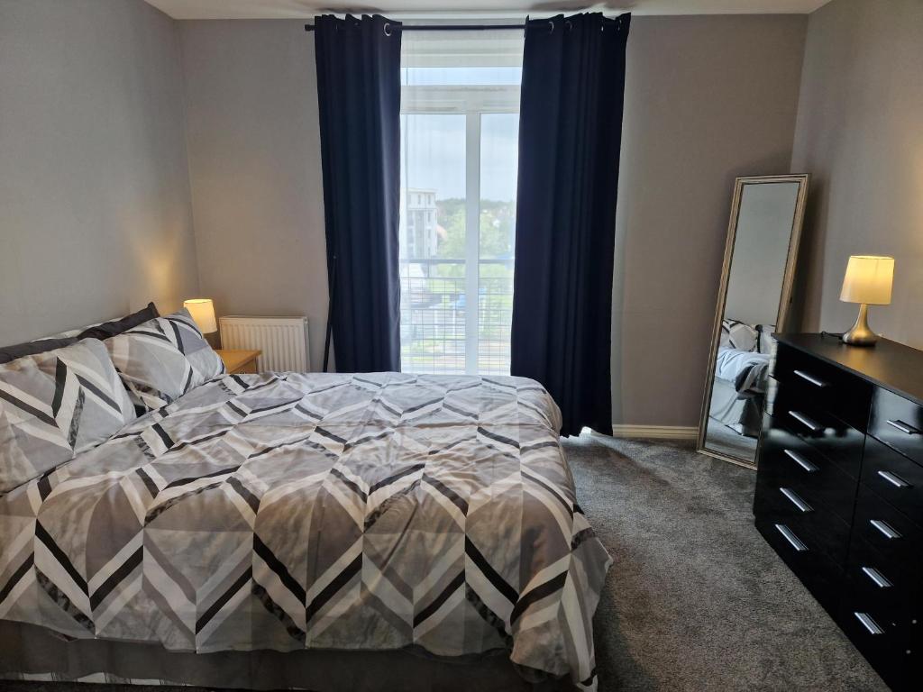 a bedroom with a bed and a large window at Stunning 2-Bed Apartment in Coventry in Coventry