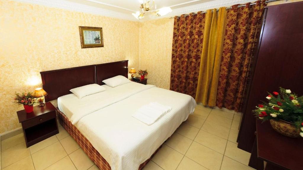 فندق الخليج للشقق الفندقية GULF HOTEL APARTMENTS في مسقط: غرفة نوم مع سرير أبيض كبير في غرفة