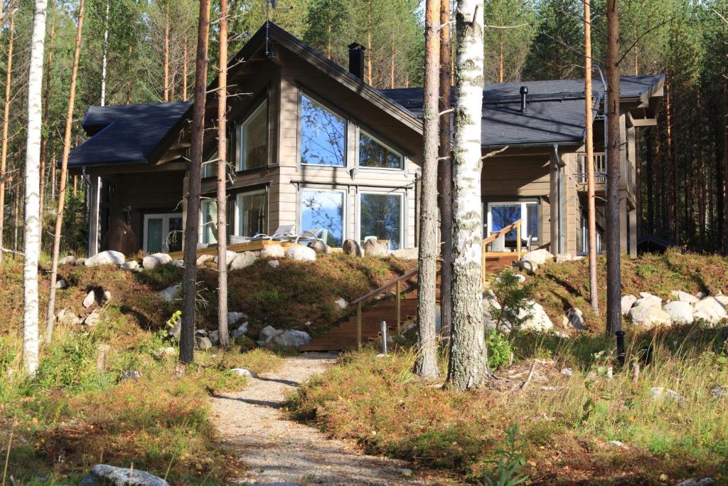 ein Haus im Wald mit einem Pfad davor in der Unterkunft Villa Tukkilahti 4 in Savonranta