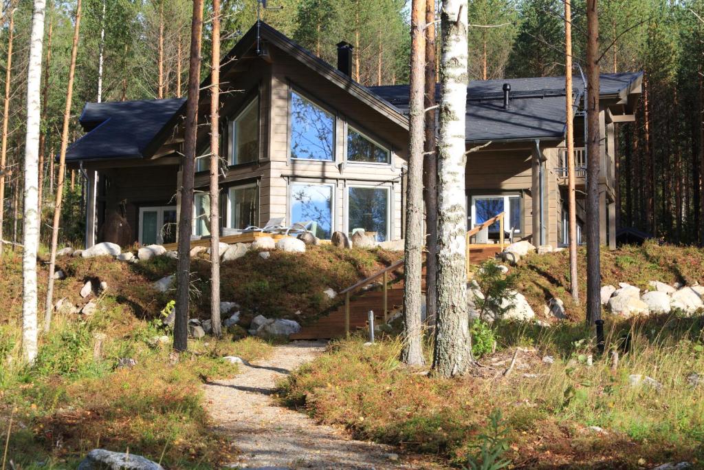 a house in the woods with a path in front of it at Villa Tukkilahti 4 in Savonranta