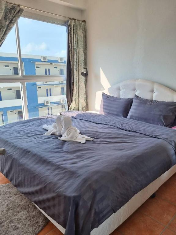 a bedroom with a large bed with a large window at Avatara B condominium B54 in Ban Tha Fat